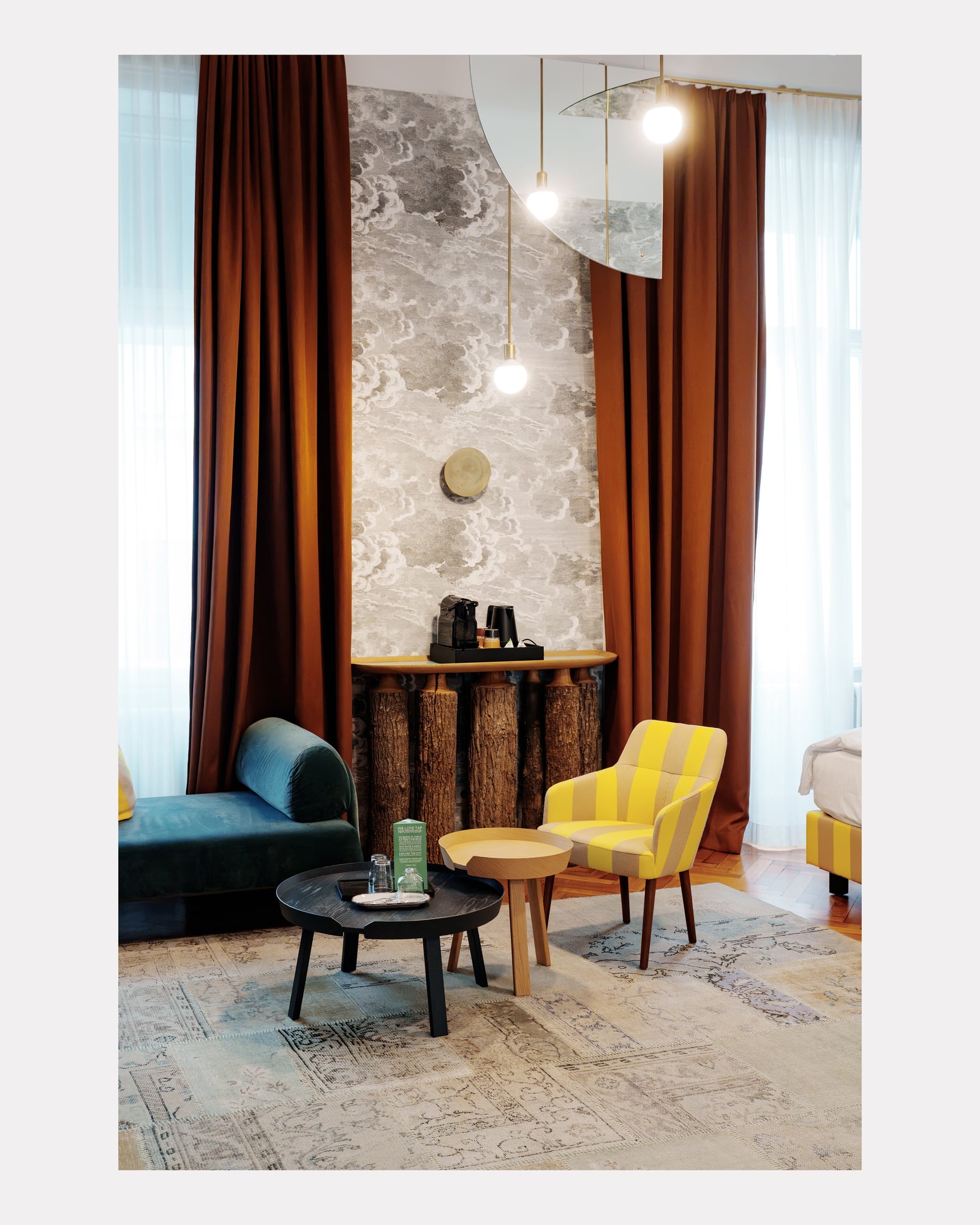 Coin salon avec rideaux rouille, fauteuils jaunes et papier peint nuages, hôtel Altstadt Vienna