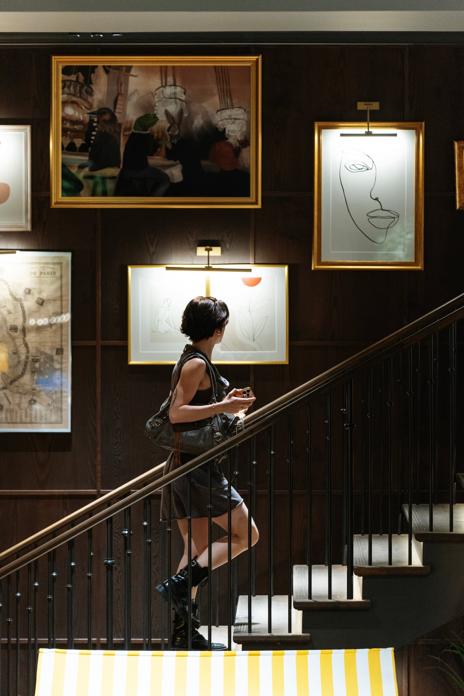 Invitée montant l'escalier devant une galerie de cadres, boutique H&M Home