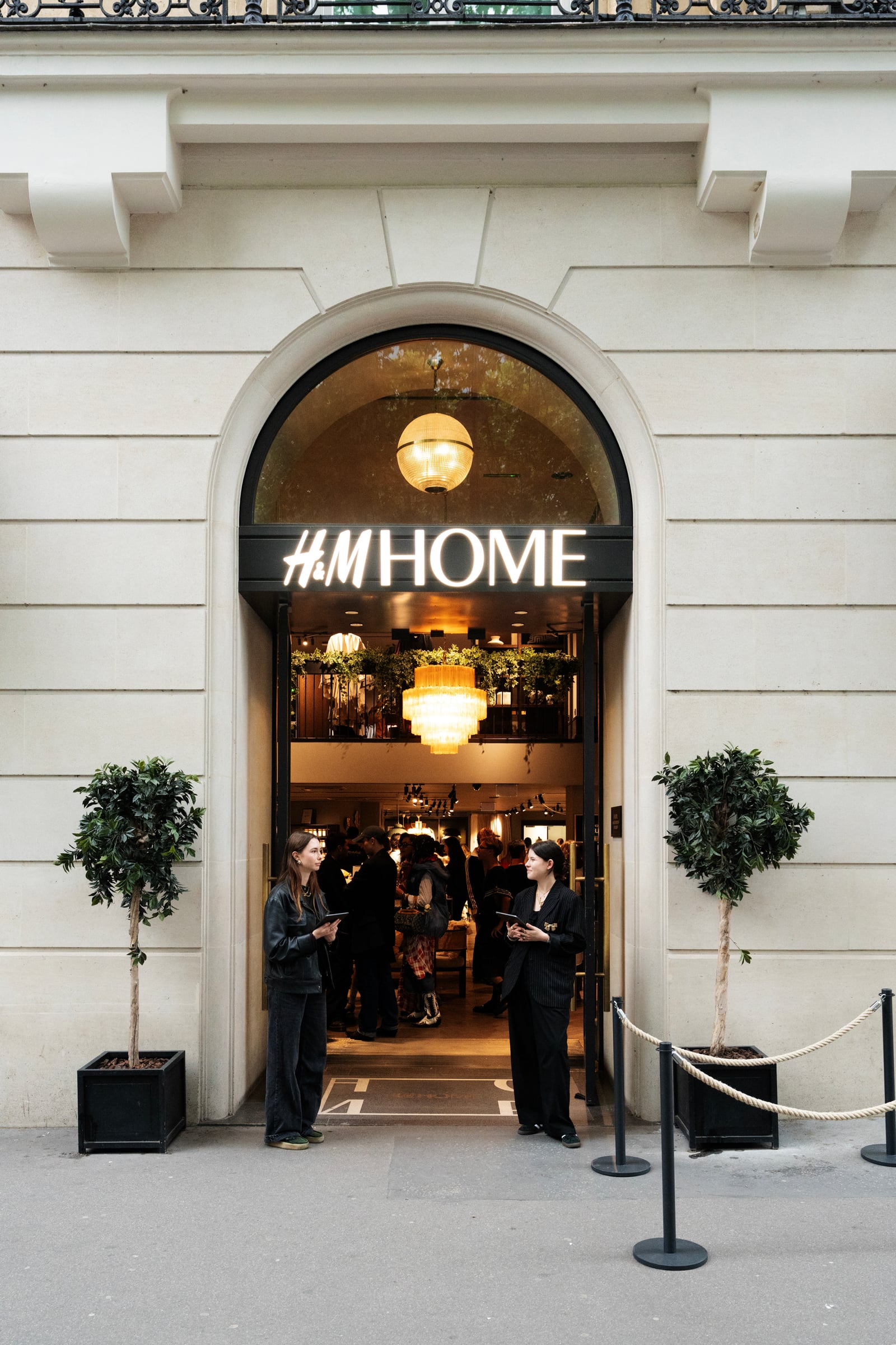 Entrée de la boutique H&M Home sous une arche, invités à l'accueil