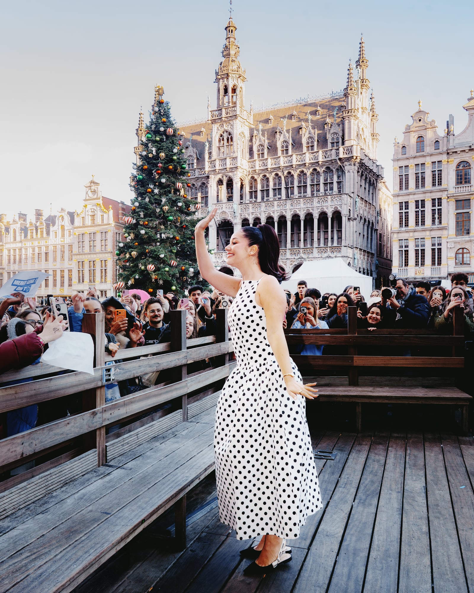 Lena Situations en robe à pois devant la foule sur la Grand-Place de Bruxelles