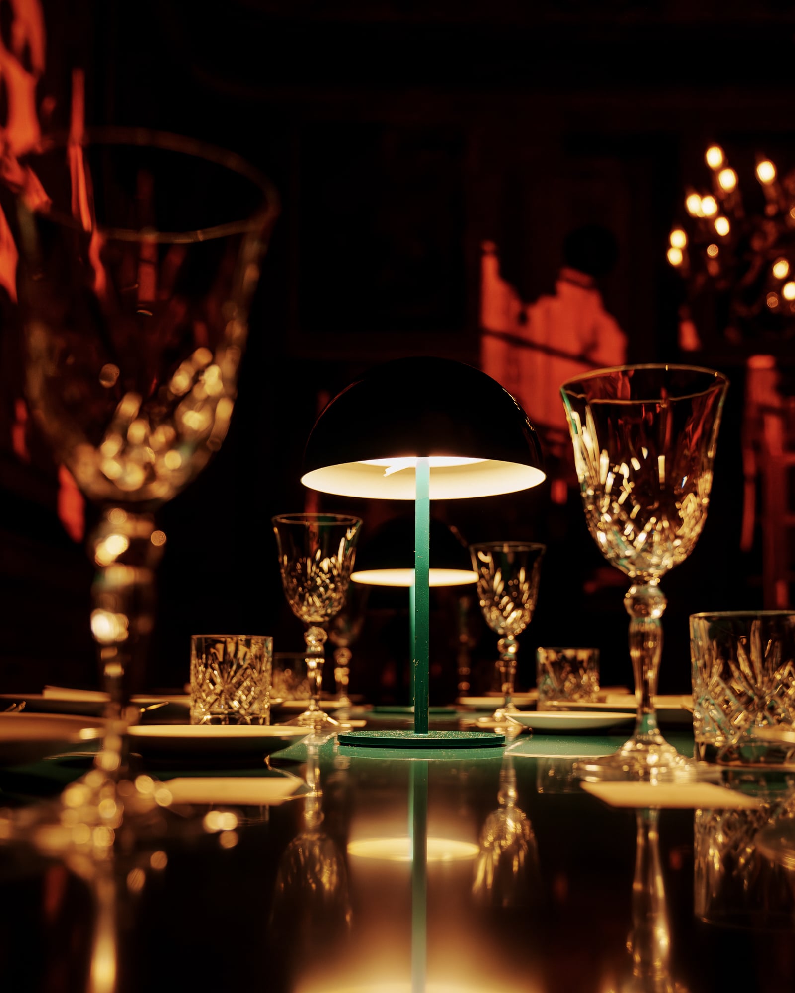 Verres en cristal et lampe verte allumée sur une table sombre, dîner de gala à Palerme