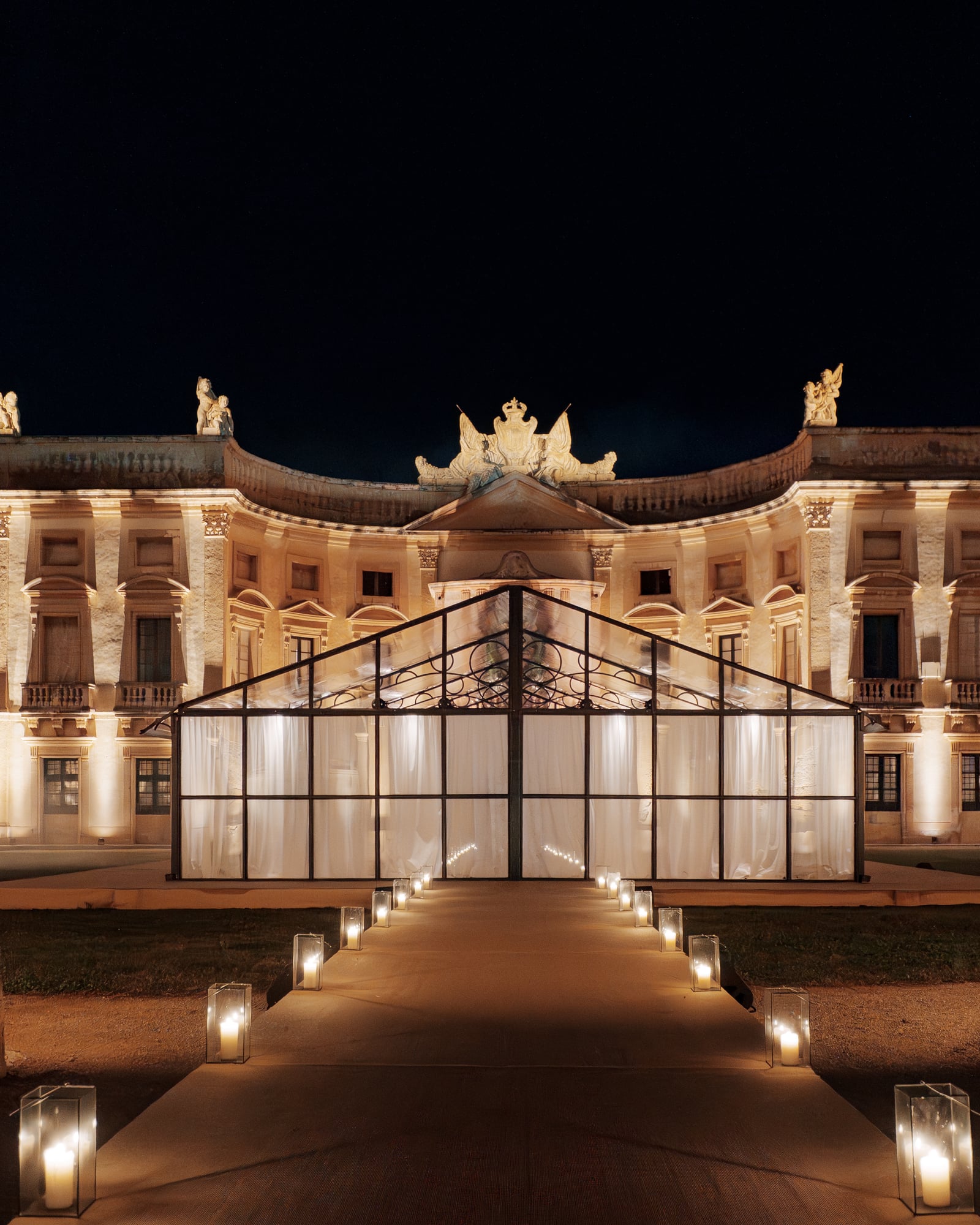 Façade d'un palais illuminée la nuit et verrière éclairée, allée de bougies, Palerme